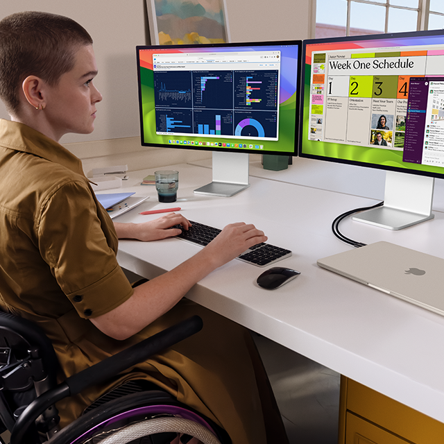 Una persona trabaja con dos monitores externos conectados a un MacBook Air de 15 pulgadas en blanco estrella cerrado
